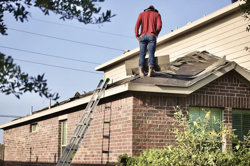 Professional roofer working on a residential roof in Alpha